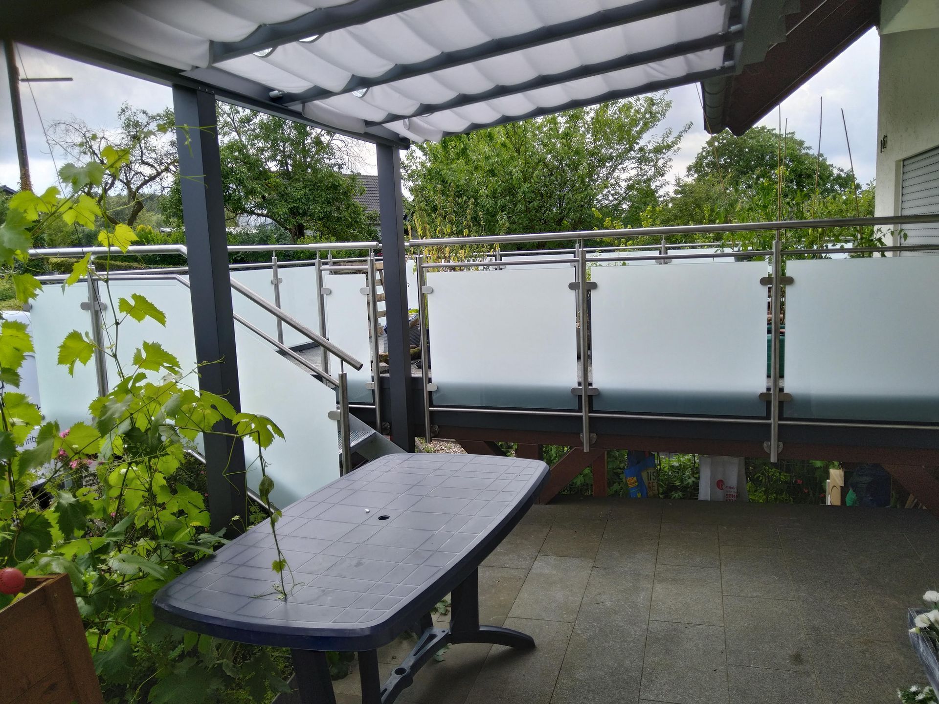 Auf dem Balkon gibt es einen Tisch und eine Bank.