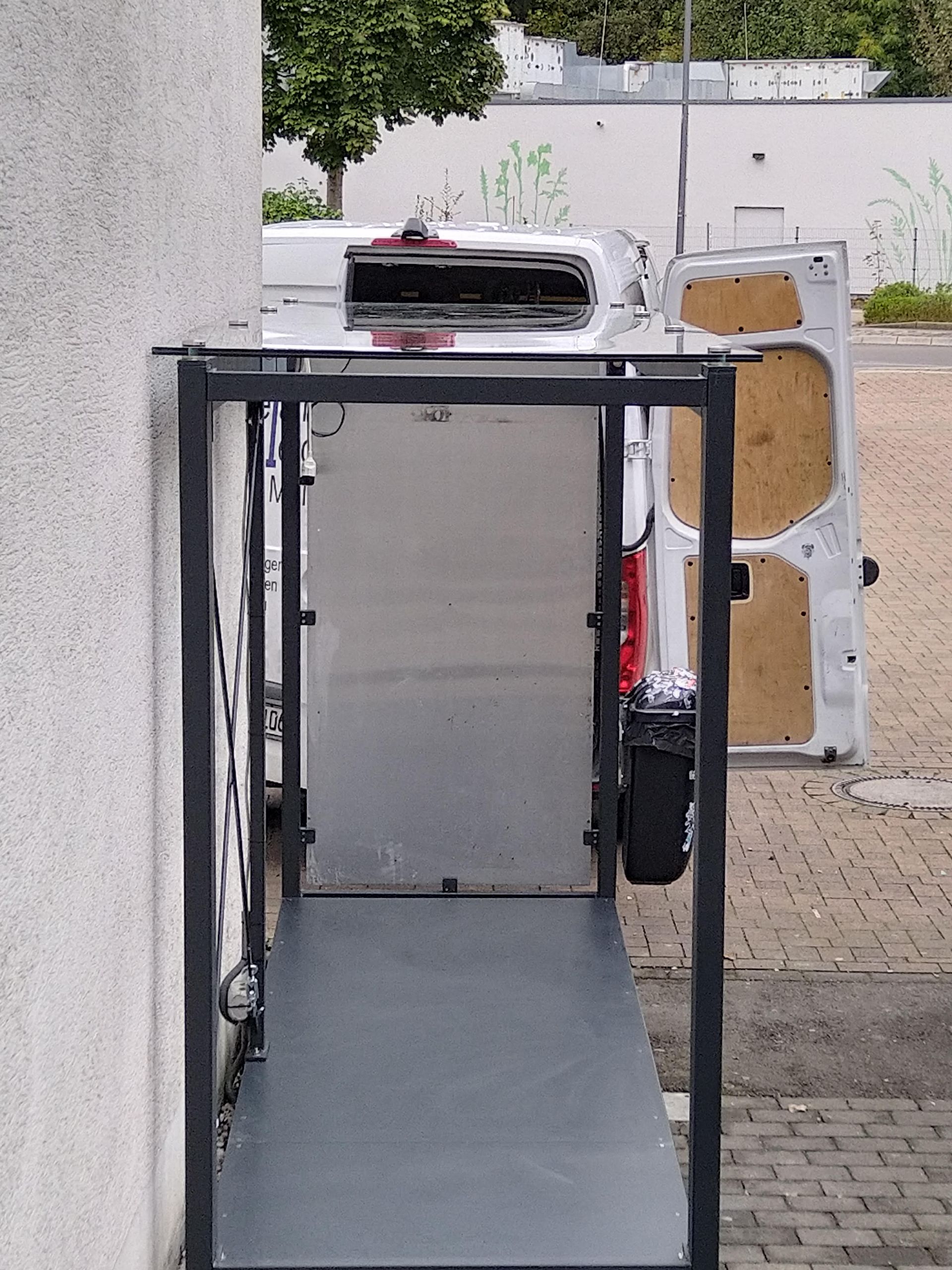 Ein weißer Lieferwagen mit offener Tür und einer Rampe, die dorthin führt