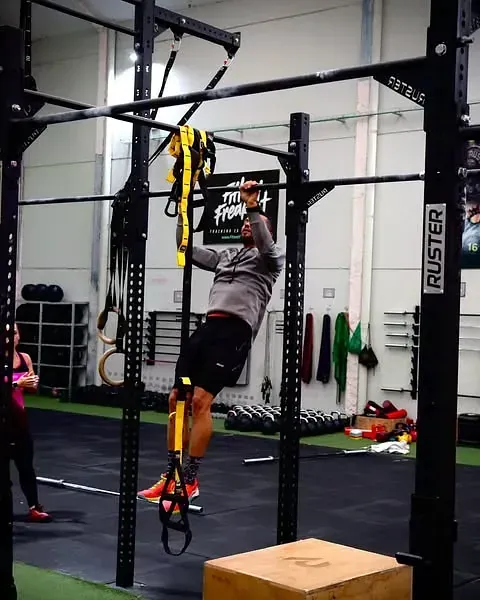 Un hombre está haciendo una dominada en un gimnasio ruster