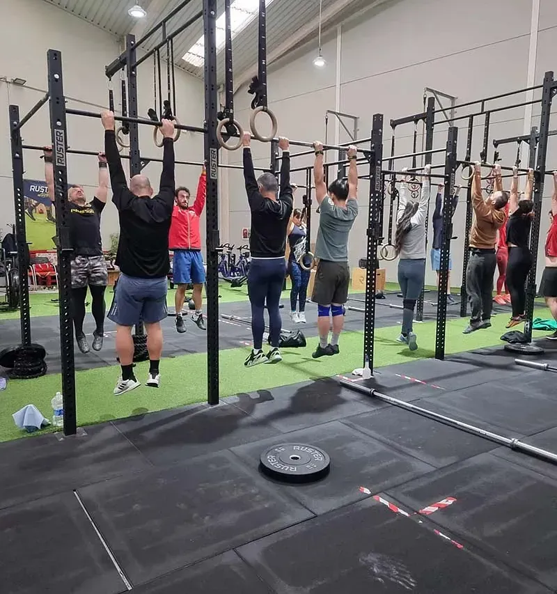 Un grupo de personas está haciendo dominadas en un gimnasio.