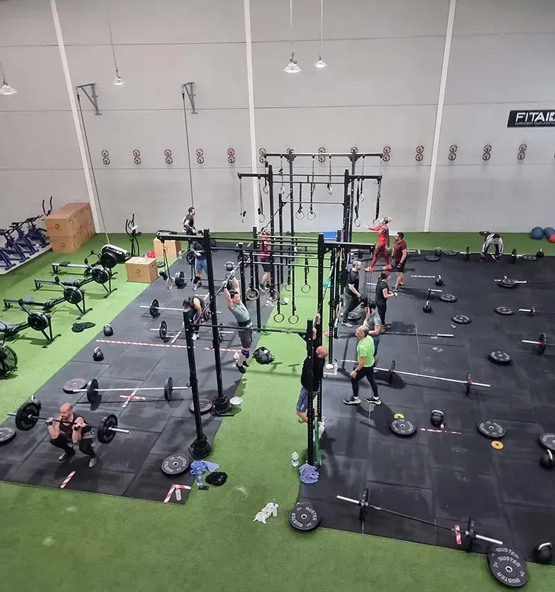 Un grupo de personas está haciendo ejercicio en un gimnasio con un cartel que dice rival.