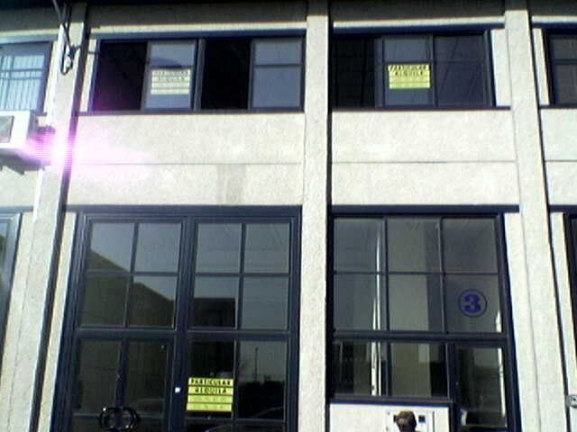 Un edificio con un cartel amarillo en la ventana que dice 'alquiler'