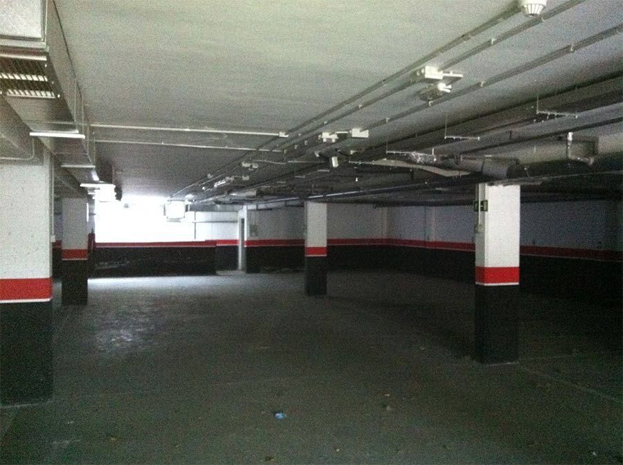 Un estacionamiento vacío con pilares rojos y blancos