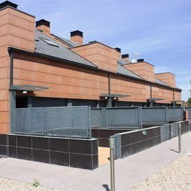 Una hilera de casas con una valla delante de ellas.