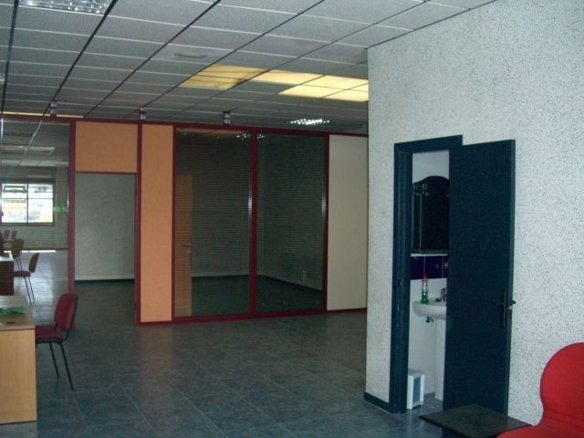Una habitación vacía con una silla roja y un lavabo.