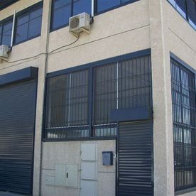 Un edificio con muchas ventanas y un buzón en el lateral.