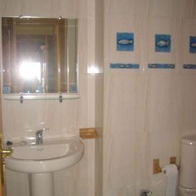 Un baño con lavabo, inodoro y espejo.