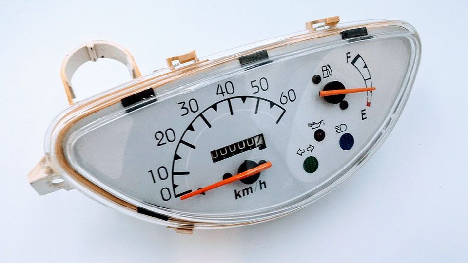 Un primer plano de un velocímetro de motocicleta sobre un fondo blanco.