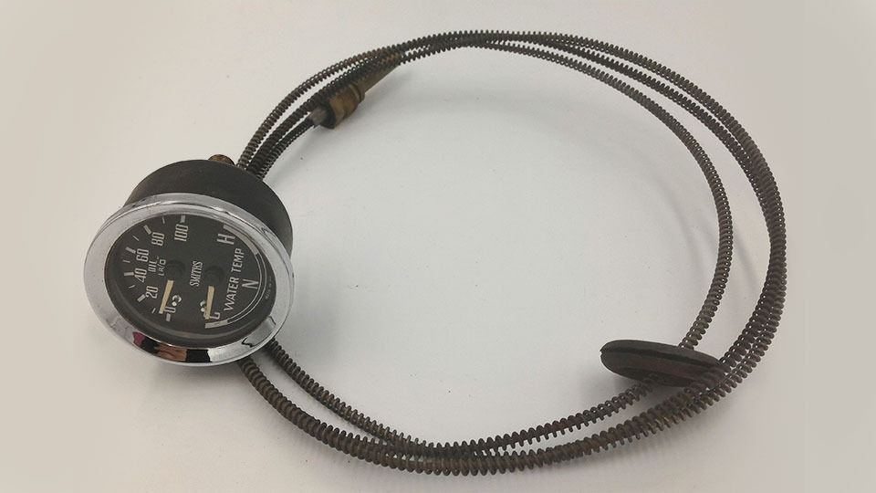 Un reloj negro y cromado con un cable conectado a él.