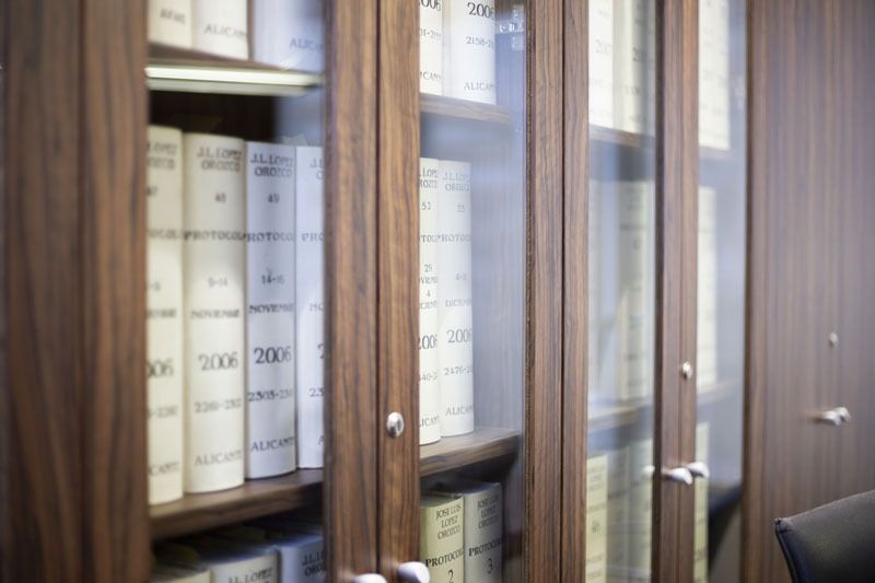 Una estantería llena de libros y una silla al fondo.