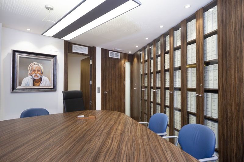 Una sala de conferencias con una mesa de madera y sillas azules.