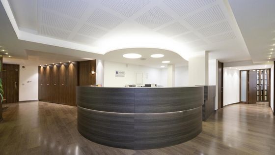 Un área de recepción con un mostrador redondo de madera.
