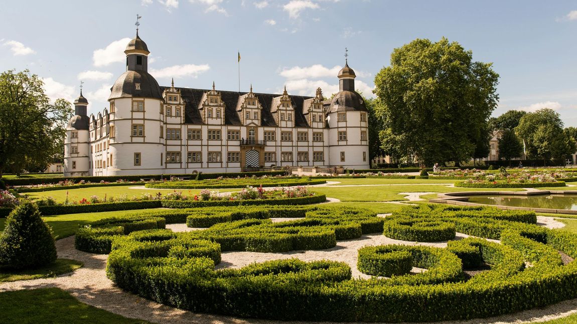 Ein großes weißes Schloss mit einem Garten davor