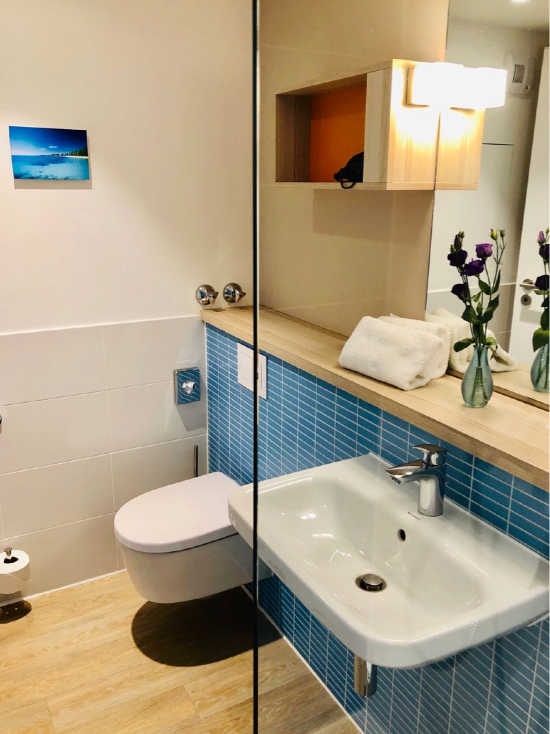 Ein Badezimmer mit Toilette, Waschbecken und Spiegel