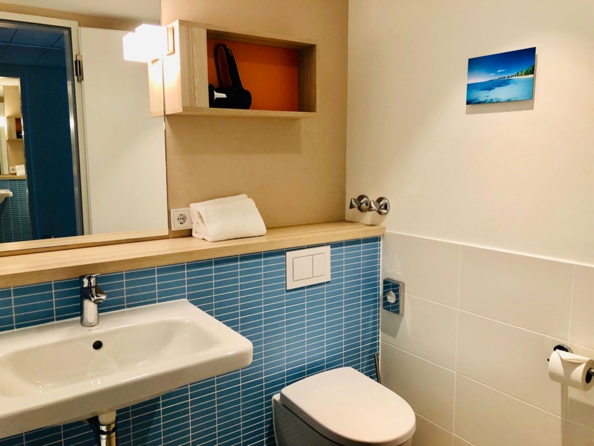 Ein Badezimmer mit blauen Fliesen und einem Waschbecken und einer Toilette