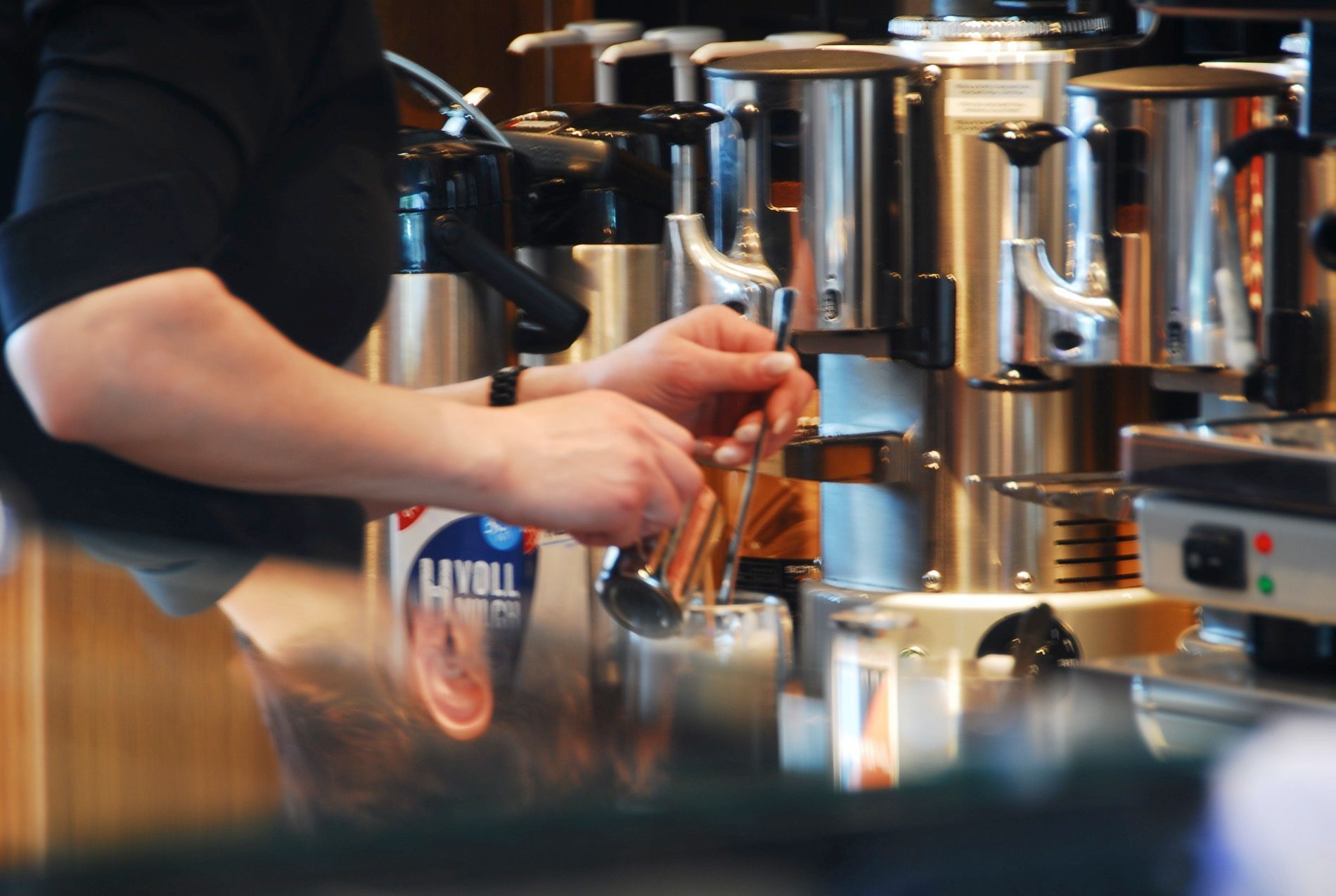 Eine Person gießt Flüssigkeit in ein Glas vor einer Flasche mit der Aufschrift „Thrift“