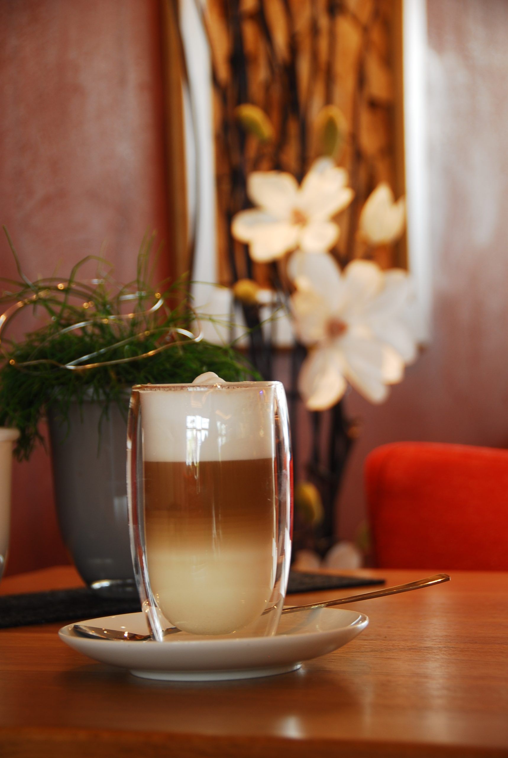 Eine Tasse Cappuccino steht auf einer Untertasse auf einem Tisch