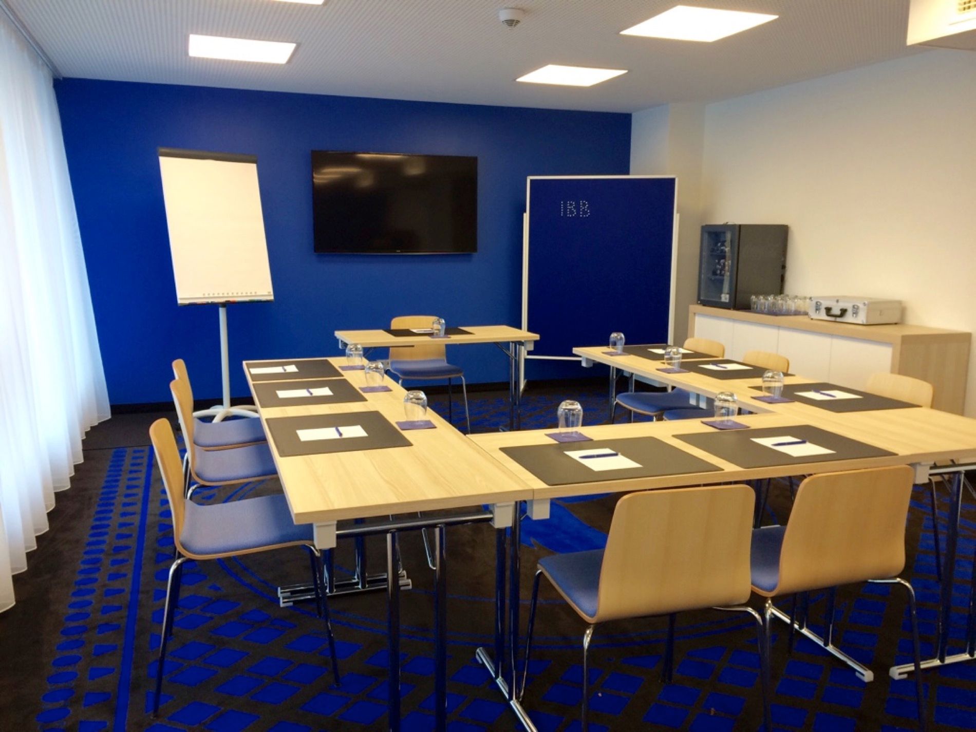 Ein Konferenzraum mit blauen Wänden und Tischen und Stühlen