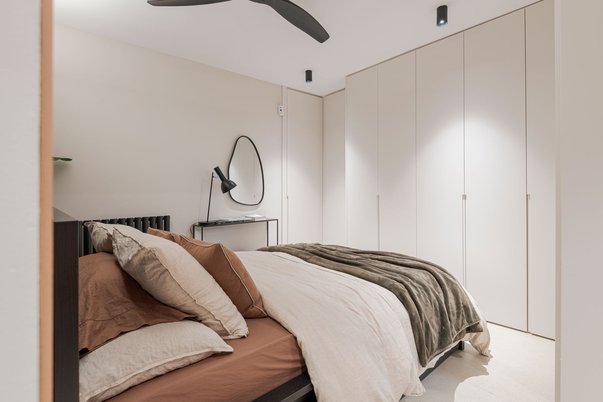 Un dormitorio con una cama y un ventilador de techo.