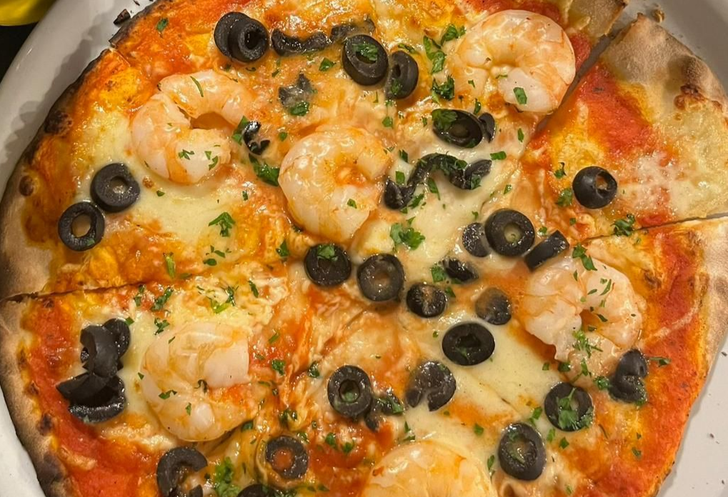 Pizza mit Garnelen und schwarzen Oliven.