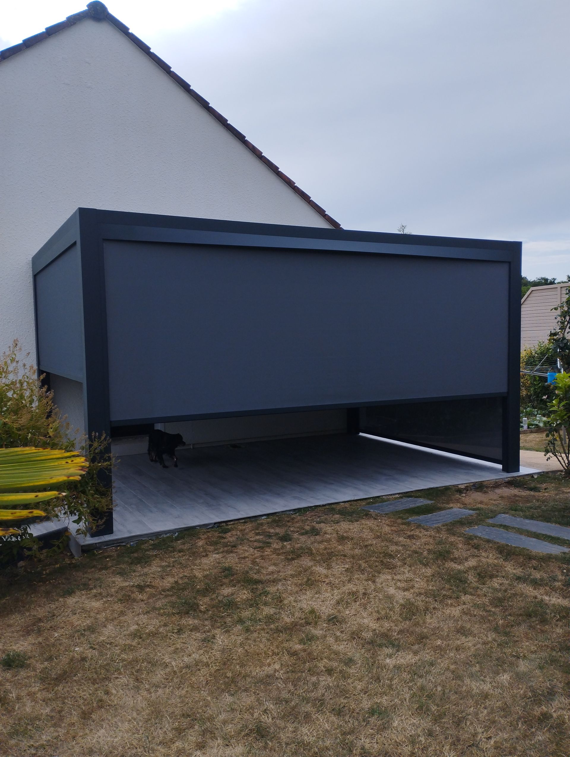 Pergola avec un store rétractable adossé à une maison