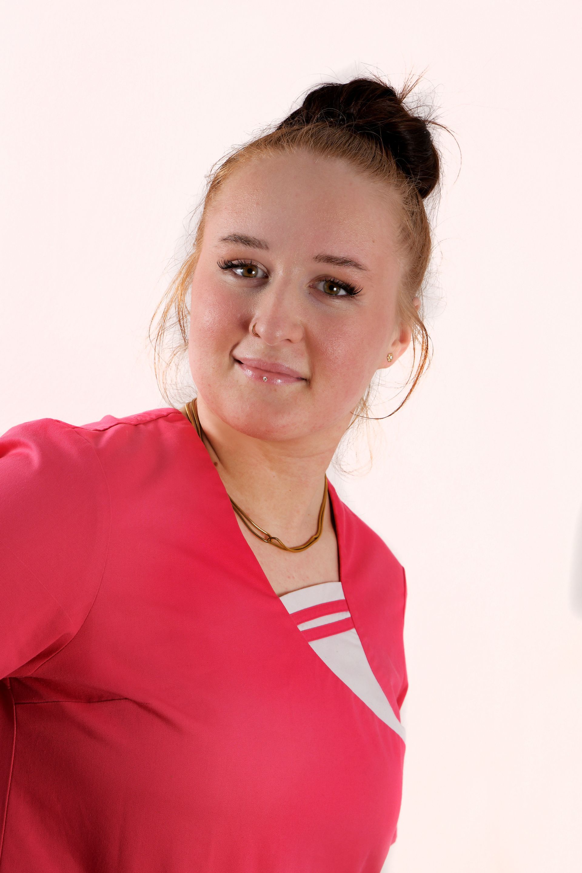 Porträt der Hauswirtschaftspflegerin Judie mit hochgesteckten Haaren und einem freundlichen Lächeln.