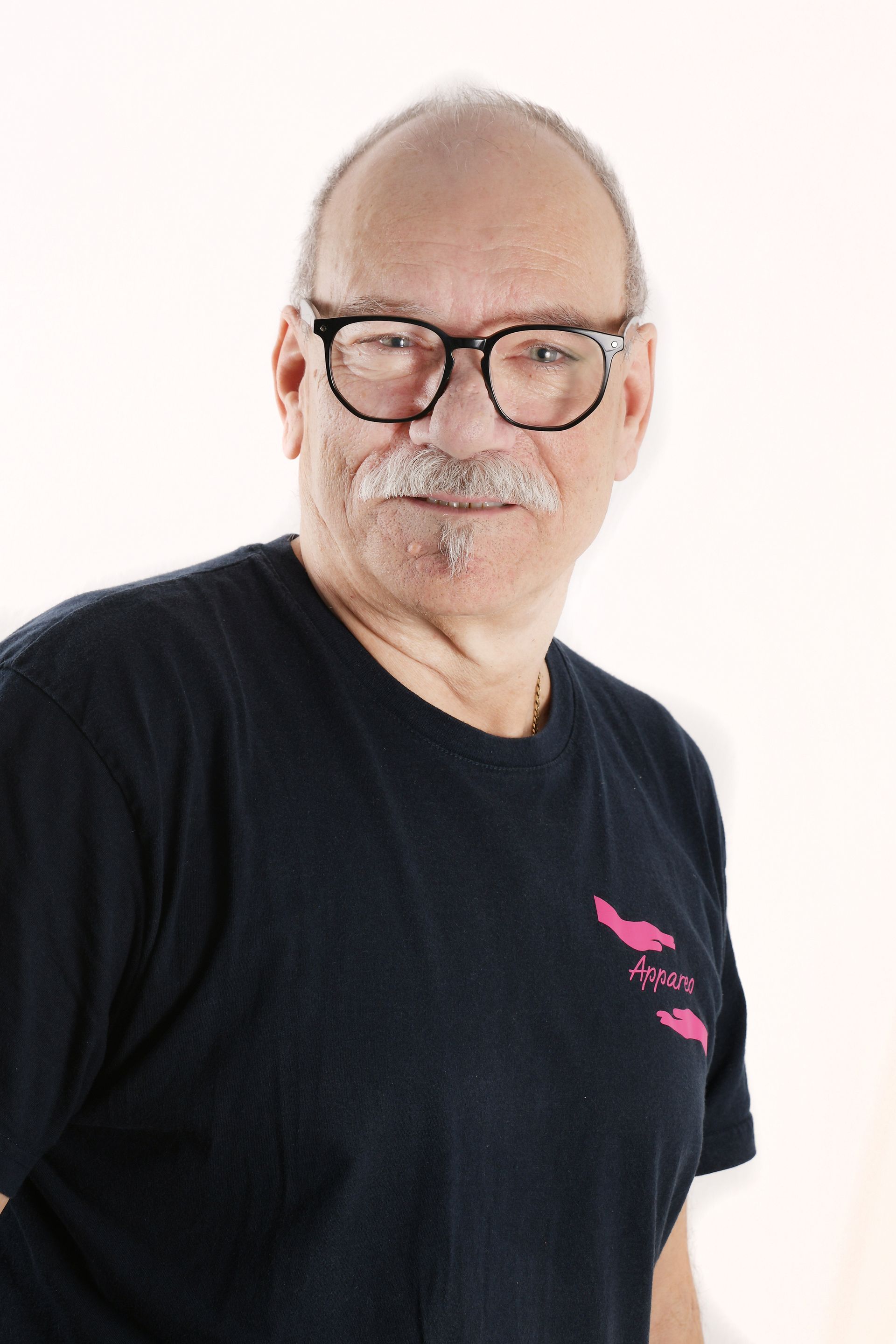 Porträt des Servicefahrers Siggi mit markanter dunkler Brille und grauem Bart.