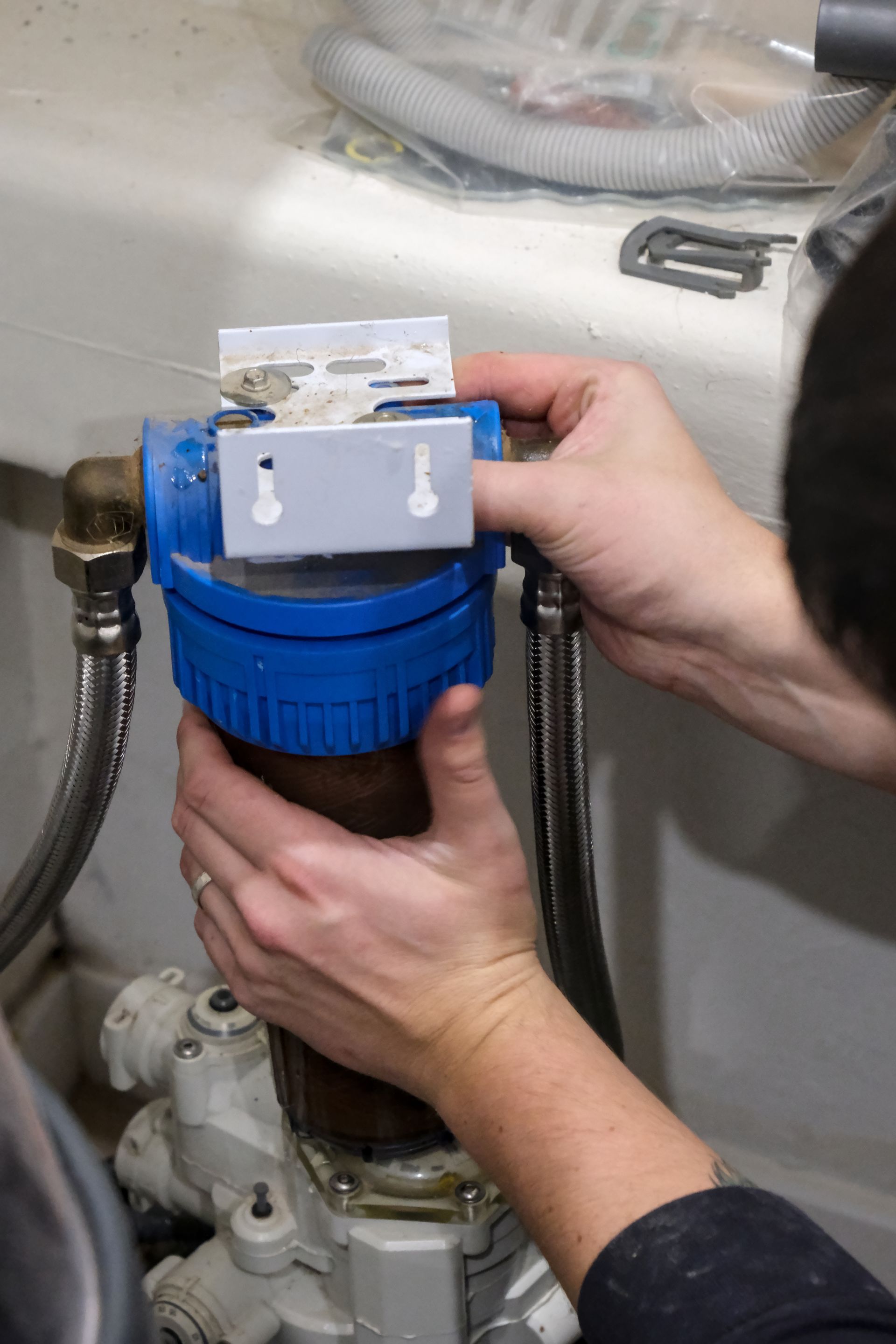 Un technicien réalise le remplacement d'une cartouche de filtre d'adoucisseur d'eau.