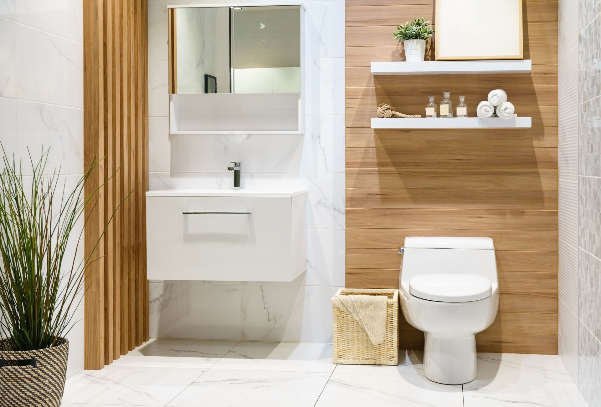 Une salle de bains avec un lavabo blanc, des toilettes et des éléments en bois.