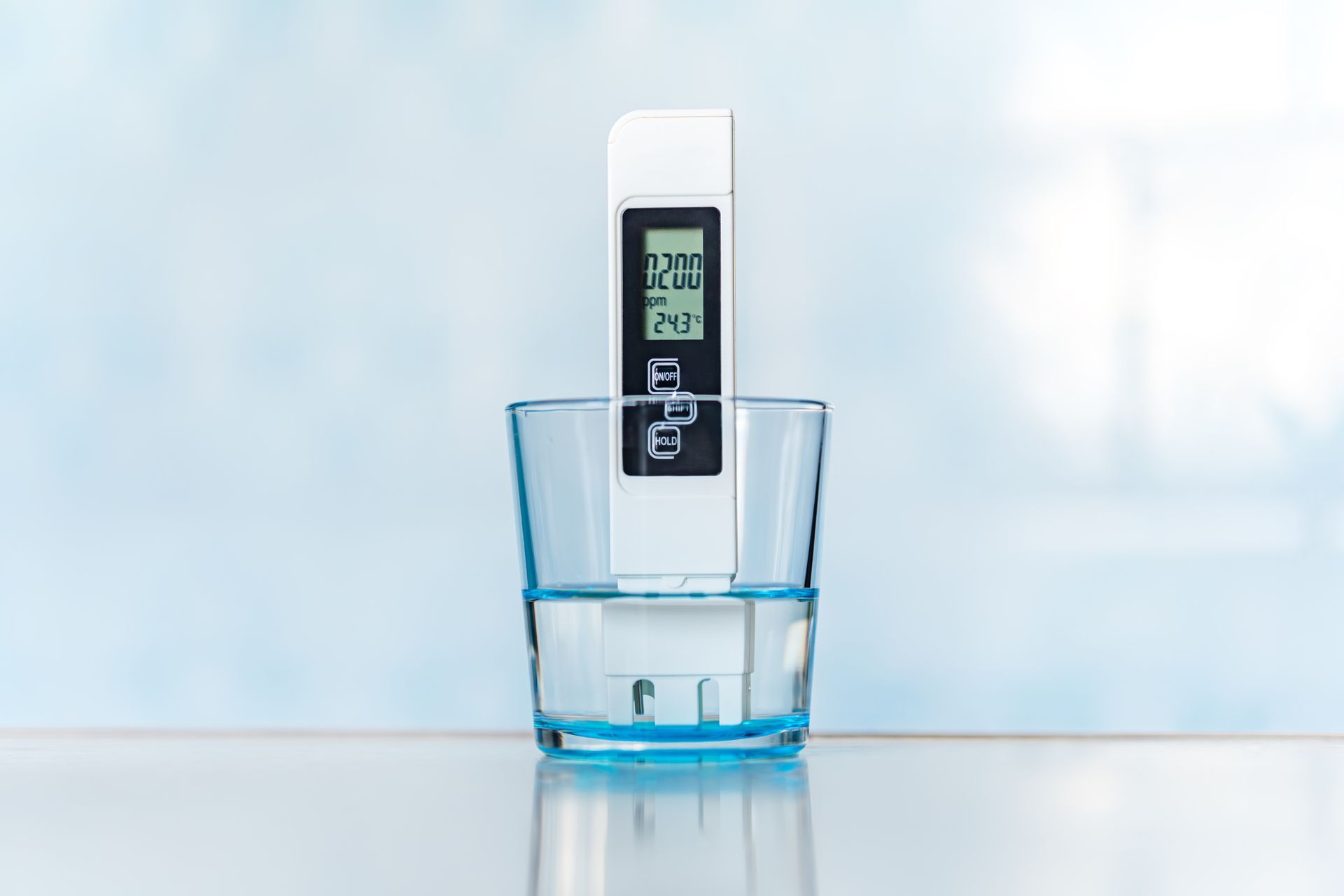 Un pH-mètre électronique dans un verre d'eau. Mauvaise qualité de l'eau, taux élevé d'impuretés salines.