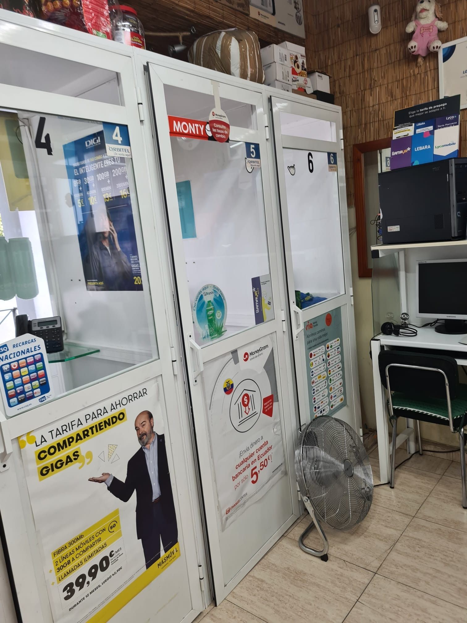Una habitación con muchos estantes y una computadora en un escritorio.