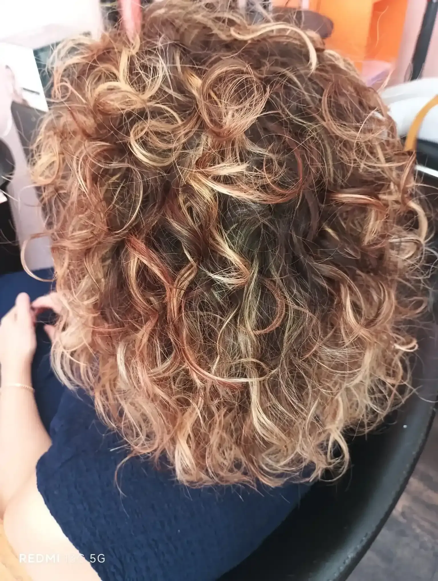 Cabello rizado castaño y rubio, peinado con rizos apretados.