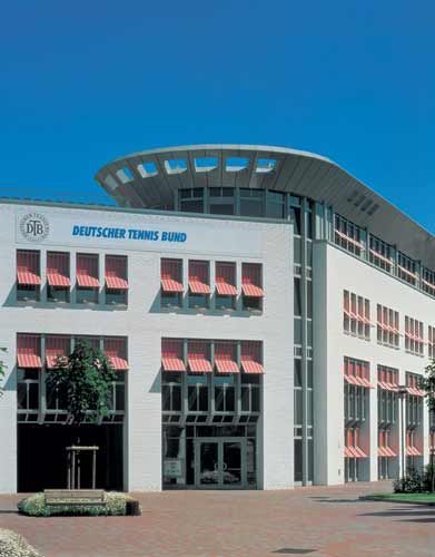 Ein großes weißes Gebäude mit einem blauen Schild mit der Aufschrift Deutscher Tennis Bund