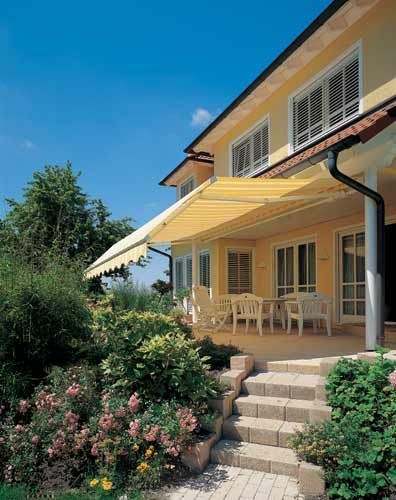 Ein großes Haus mit einer gelben Markise auf der Veranda