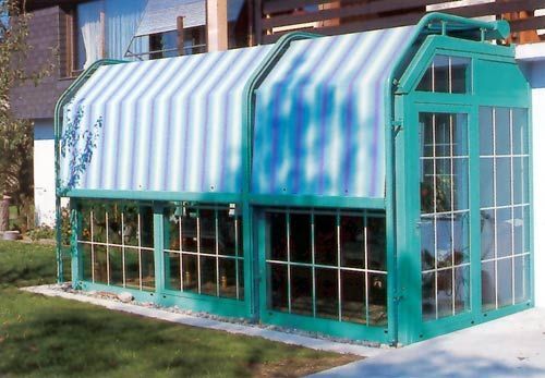 Ein Gewächshaus mit einer blau-weiß gestreiften Markise