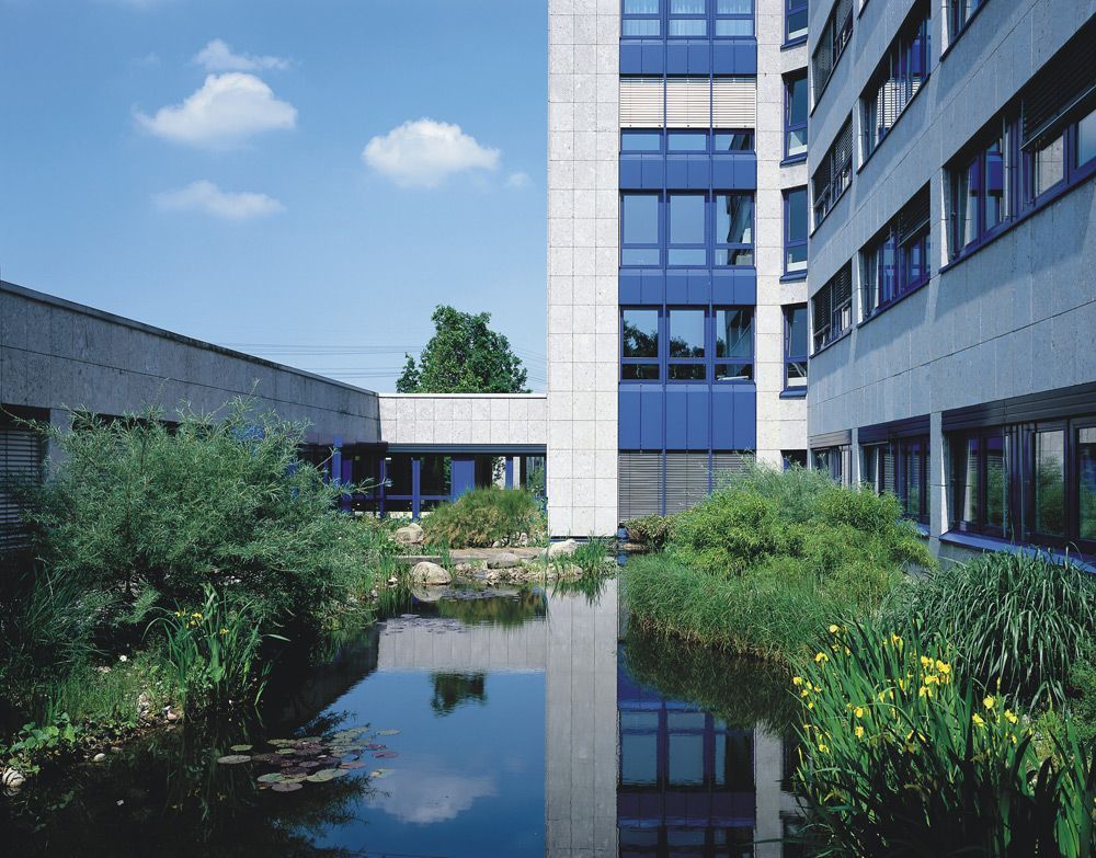 Ein großes Gebäude mit einem Teich davor