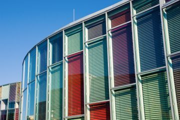 Ein Gebäude mit vielen Fenstern und einem blauen Himmel im Hintergrund