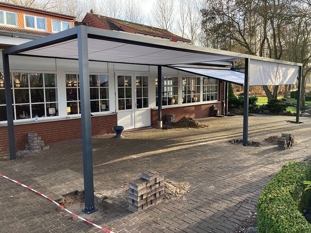 Ein Innenhof mit einem Baldachin darüber und einem Backsteingebäude im Hintergrund.