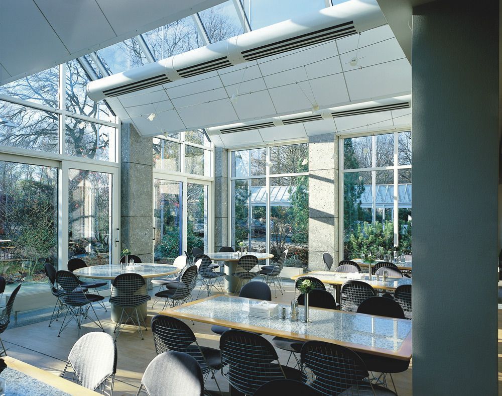 Ein großer Raum mit Tischen und Stühlen und vielen Fenstern