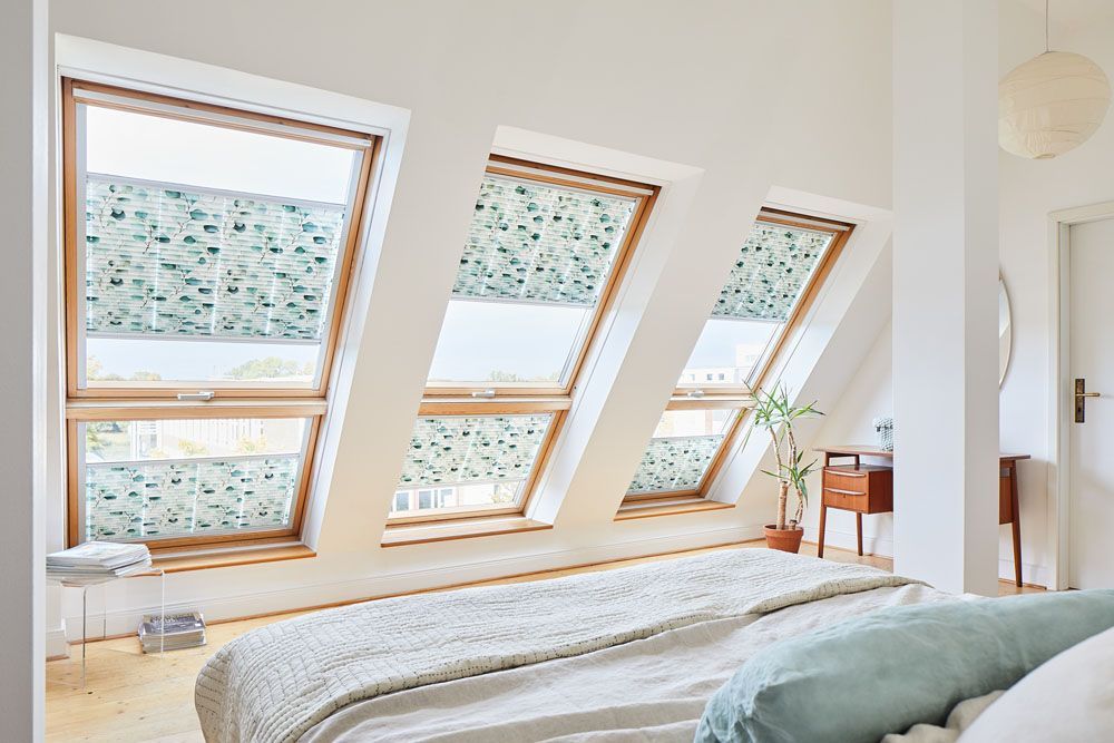 Ein Schlafzimmer mit einem Bett und vielen Fenstern.