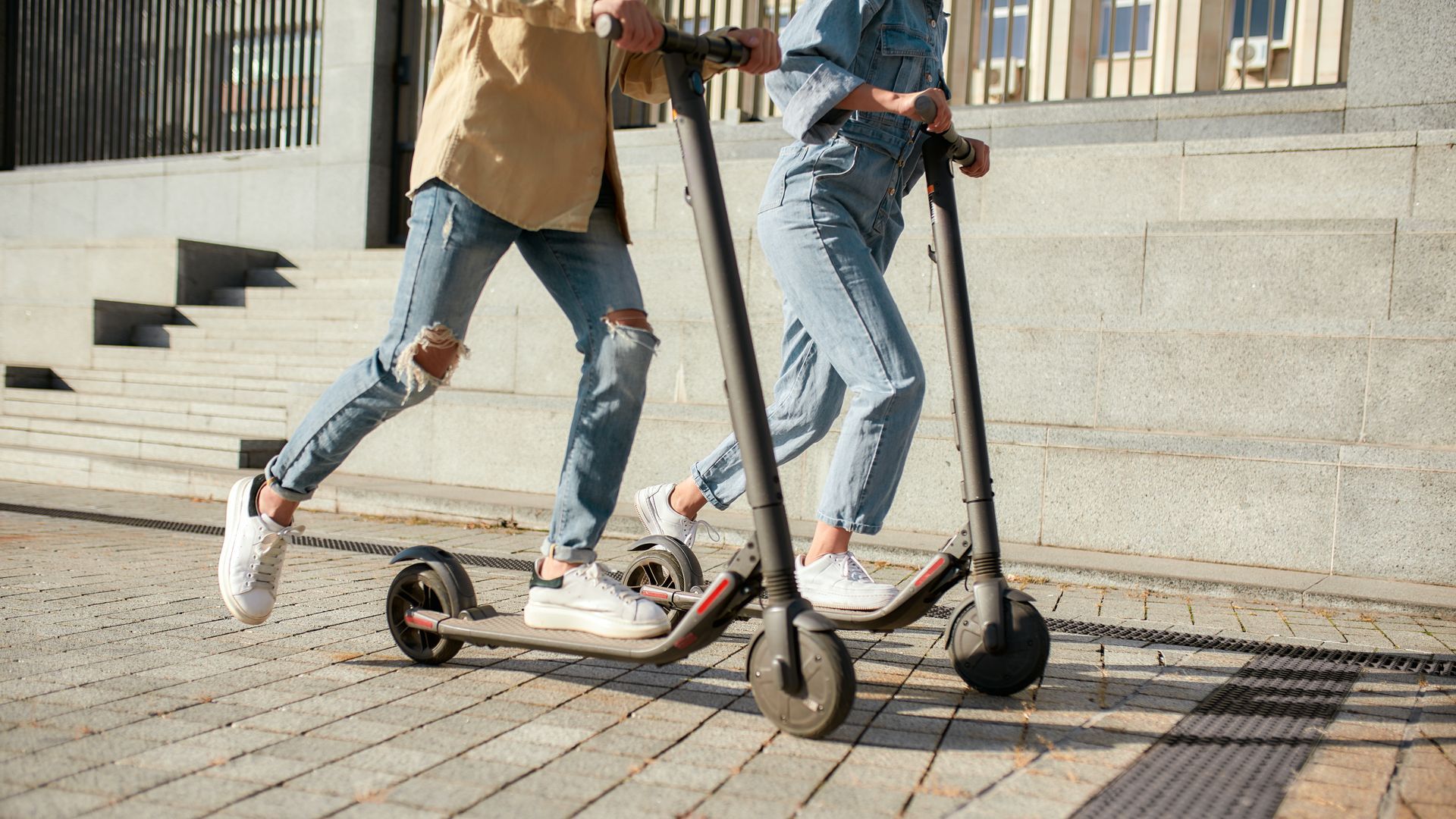 Deux personnes roulant chacune sur une trottinette électrique
