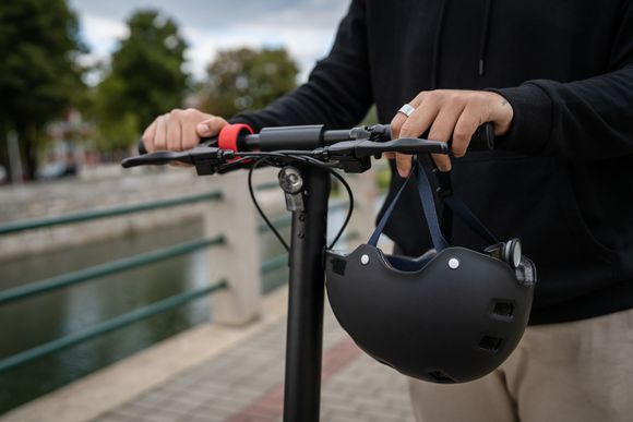 Casque accroché à la poignée d'une trottinette électrique