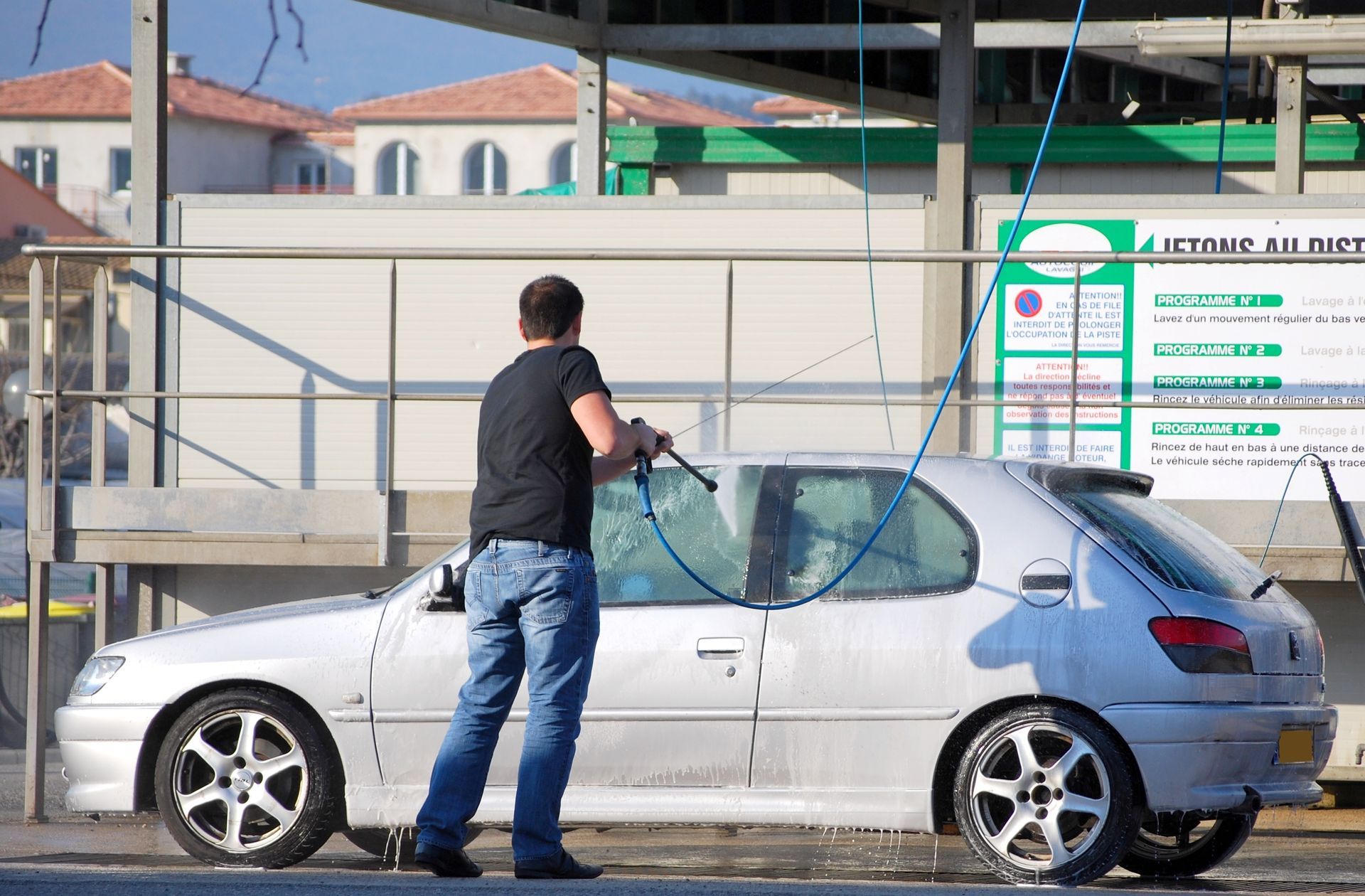 Homme nettoyant sa voiture à la station de lavage