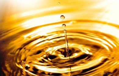 Goldene Flüssigkeit mit Wellen, Tropfen fallen herab.