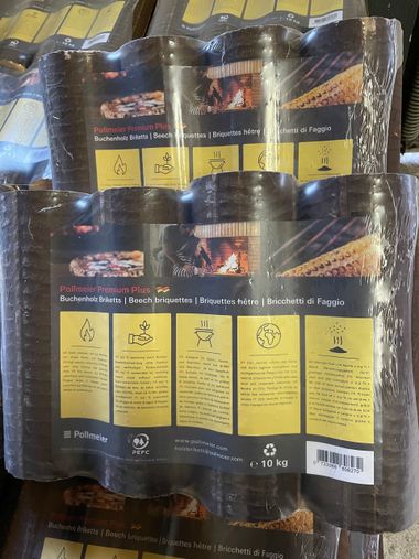 Gepresste Holzbriketts, gestapelt und in durchsichtige Plastikfolie eingewickelt.
