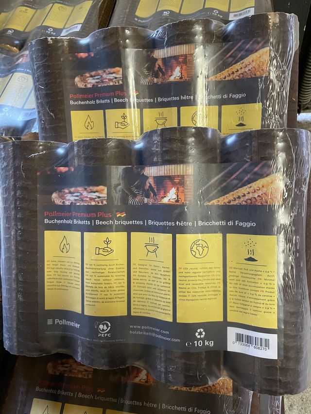 Gepresste Holzbriketts, gestapelt und in durchsichtige Plastikfolie eingewickelt.