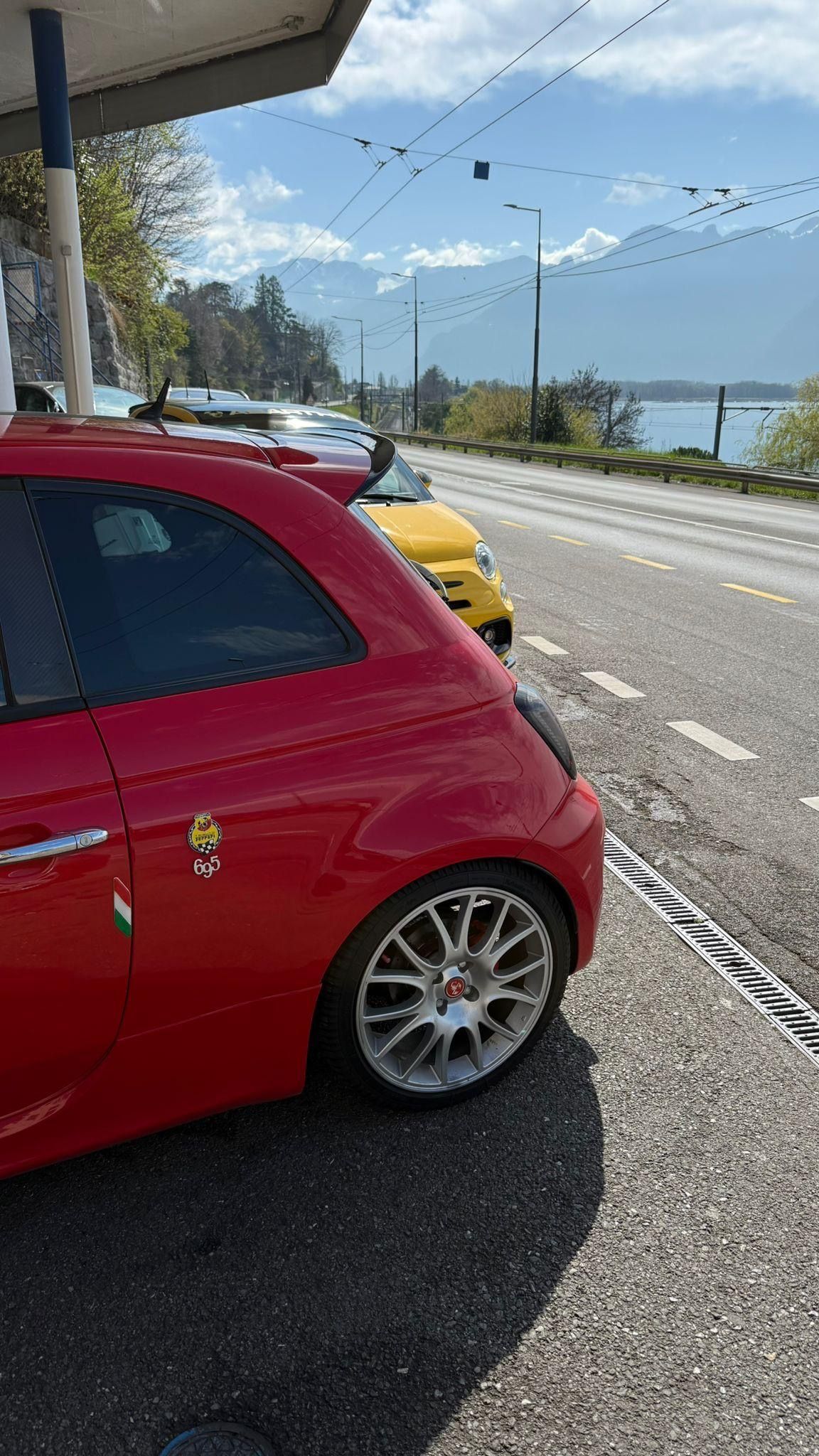 Une voiture est en réparation dans un garage avec un pneu par terre.