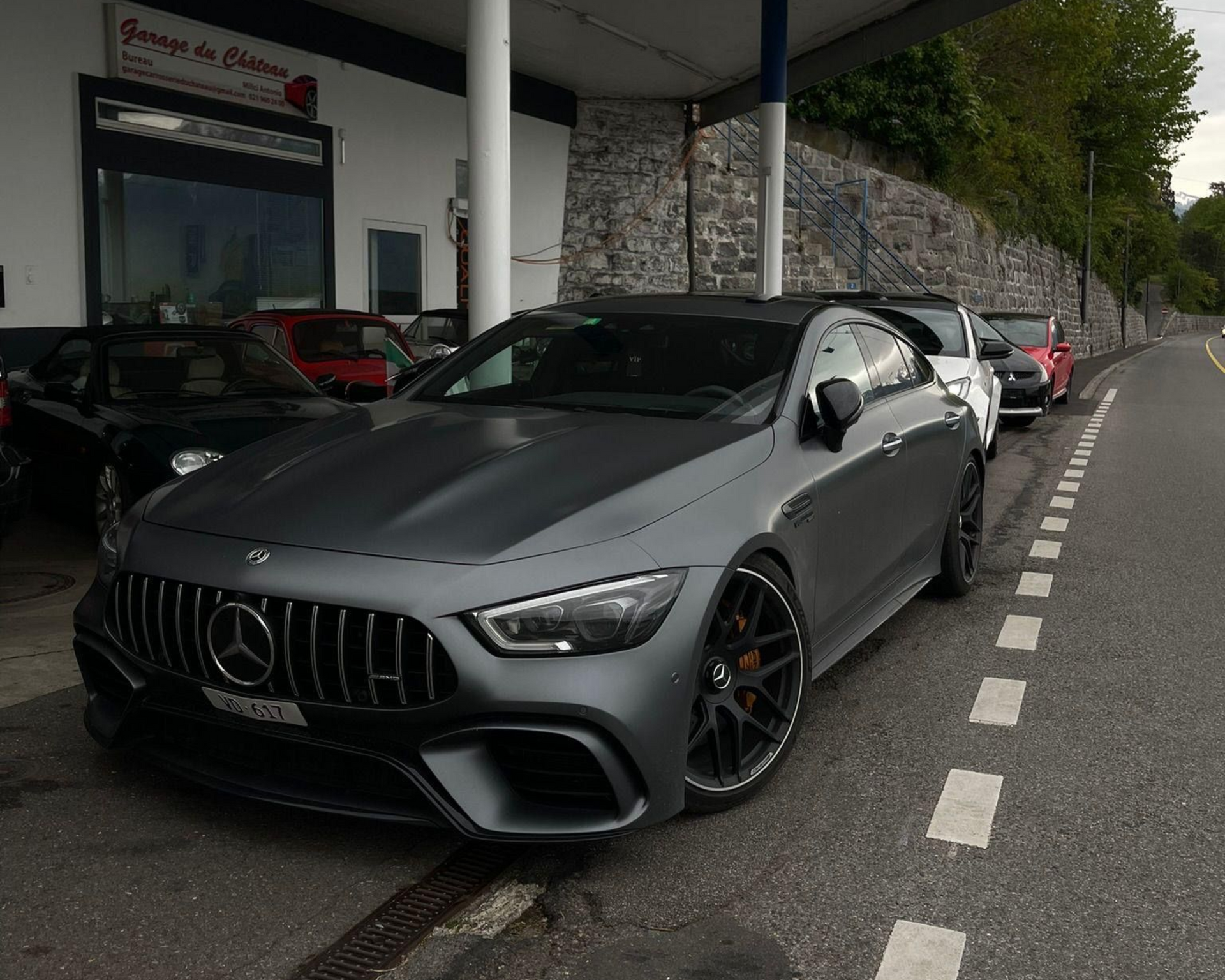 Voiture Smart rouge décapotable garée devant le Garage du Château.