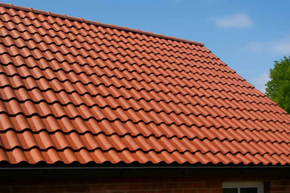 Ein rotes Ziegeldach mit einem blauen Himmel im Hintergrund