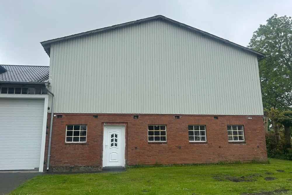 Ein großes Backsteingebäude mit einer weißen Tür und einem weißen Garagentor.